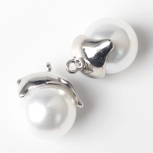 Close-up of pearl dolphin charms with silver metal caps for DIY jewelry making