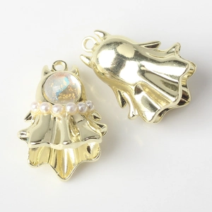 Macro view of gold Halloween ghost pendant with iridescent stone and pearl accents