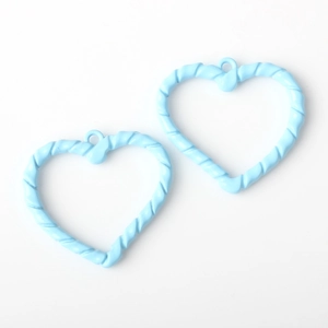Primer plano de colgantes de corazón azul claro con textura en espiral para joyería DIY