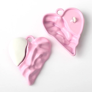 Detail of pink and white wavy textured heart pendants for DIY jewelry making