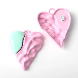 Detailed view of pink and mint green heart-shaped DIY jewelry pendants with wavy texture