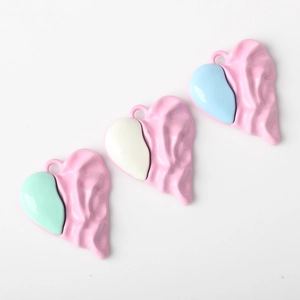 Detailed macro of heart pendants with pleated pink texture and smooth pastel metal