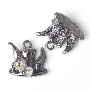 Detail of gunmetal Halloween charms with star pattern and clear zircon insets