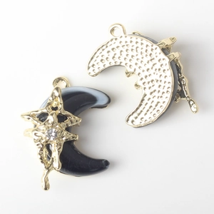 Detail of moon and star resin pendant with gold plating and cubic zirconia inlay