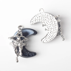 Detailed view of moon and star charms with marble resin inlay and sparkling crystals