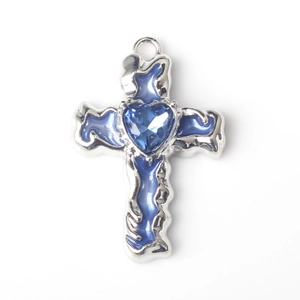 Detailopname van een kruishanger in vloeibare stijl met blauw hartkristal en emaille