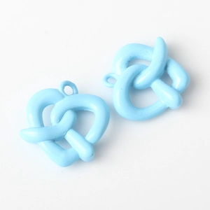 Detalle de dijes de pretzel azul con forma de corazón y anillos para joyería DIY
