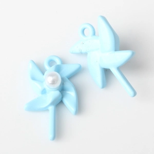 Close-up of light blue windmill charms with pearl inlay for DIY jewelry making