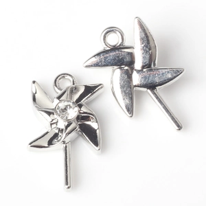 Detail of silver windmill charms with pearl inlay showing front and back metal structures
