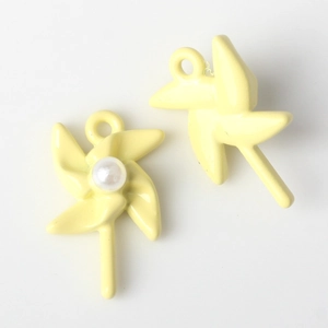 Detail of yellow windmill alloy charms with pearl inlay for DIY jewelry making