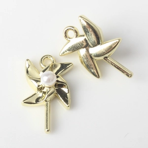 Macro shot of gold windmill pendant charms with pearl inlay for DIY jewelry making