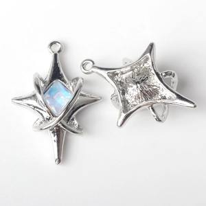 Dettaglio macro del ciondolo a stella argento con zircone incastonato e retro metallico
