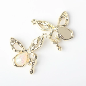 Detail of alloy butterfly charms with opal inlay and smooth metallic back texture