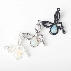 Macro detail of alloy butterfly pendants with synthetic opal inlay for DIY jewelry
