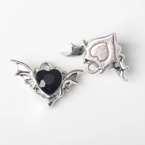 Macro shot of silver bat wing heart charms with black zircon for DIY jewelry making