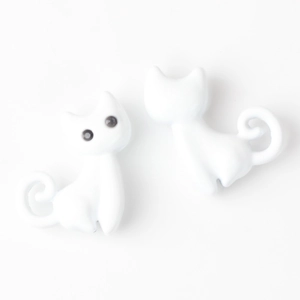 Détail macro de deux mignons pendentifs chat 3D blancs pour colliers et bijoux DIY