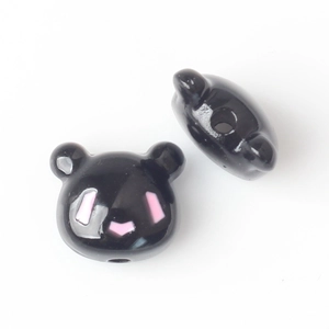 Detailed view of black bear beads with pink accents for DIY jewelry making and crafts