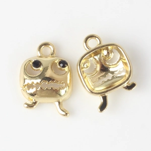 Detailed close-up of golden ghost charms with wave-shaped mouths and black bead eyes