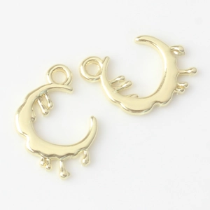 Detailed close-up of two irregular gold crescent moon pendants with a liquid metal texture