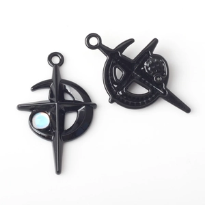 Detail of two black alloy pendants with cross, crescent moon and star for DIY jewelry making