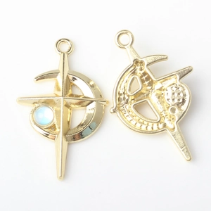 Macro detail of gold moon and cross charms with inlaid blue beads for DIY jewelry making