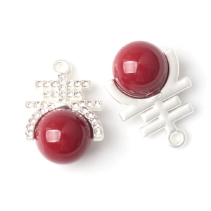 Makroansicht der silbernen Xi-Anhänger mit roten Perlen und Diamanten für DIY-Schmuck
