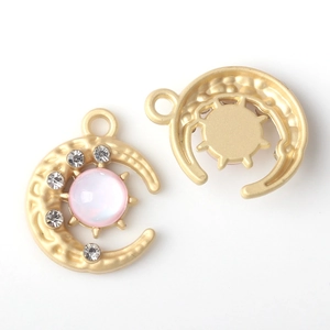 Détail du pendentif lune et soleil avec pierre rose et strass blancs brillants