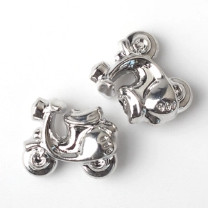 Dettaglio macro di ciondoli scooter vintage in argento lucido per bracciali e gioielli DIY