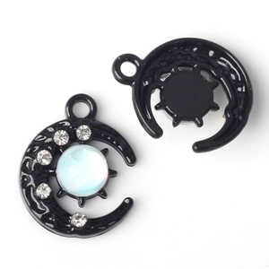 Détail macro du pendentif croissant de lune noir avec opale bleue et diamants