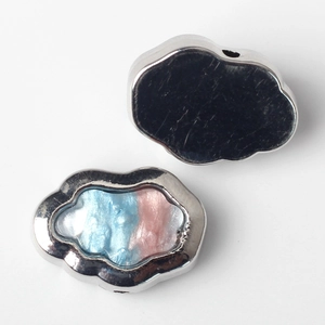 Detailed view of silver alloy cloud charms with blue and pink resin inlay for DIY jewelry