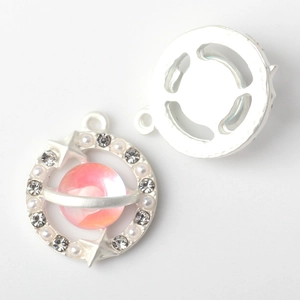 Detailed close-up of planet pendant with pink crystals and pearls for jewelry making