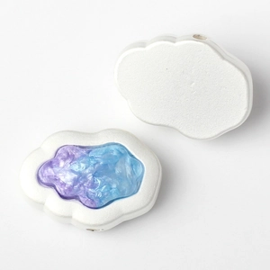 Macro shot of cloud-shaped DIY beads with pearlescent finish and blue resin inlay