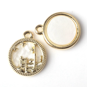 Detailed macro view of golden castle coin pendants with intricate white enamel inlay