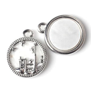 Detailed macro of silver castle coin pendants with embossed patterns and smooth finishes