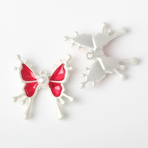 Detalle del colgante de mariposa de aleación con esmalte rojo e incrustación de perla