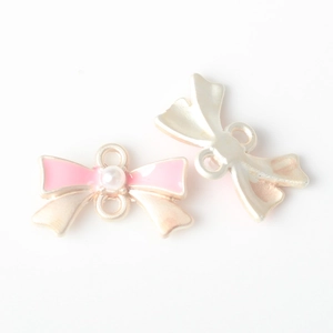Détail du connecteur de bijou nœud en émail rose avec perle et doubles anneaux de lien