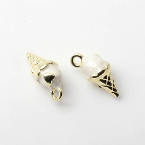 Close-up of gold-plated ice cream pendants with white enamel and heart detail