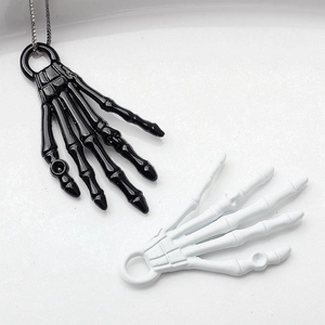 Detailansicht der gotischen Skeletthand-Anhänger in Schwarz und Weiß lackiert
