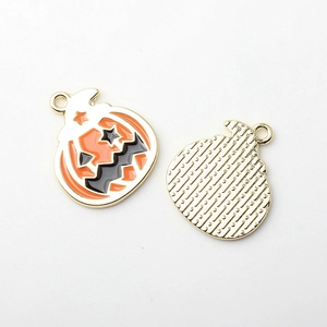 Detalle de colgantes de calabaza de Halloween con esmalte naranja y reverso dorado liso