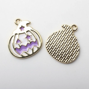 Detalle de colgante de calabaza de esmalte morado y blanco con reverso de metal dorado y aro