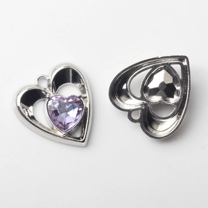 Détail macro du pendentif cœur avec zircon violet et monture en alliage ton argent