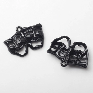 Detail of glossy black comedy and tragedy drama mask charms for jewelry making
