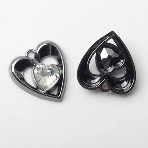 Détail de pendentifs en forme de cœur avec couches ajourées et cristaux incrustés