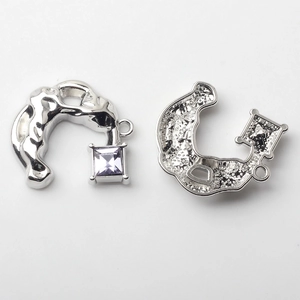 Detail of silver C-shape alloy pendants with square purple zircon for DIY jewelry making