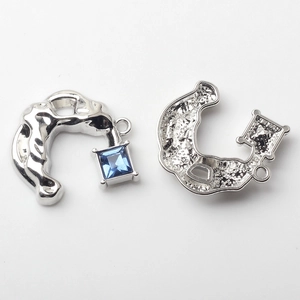 Detail of silver alloy C-shape charm with square blue gemstone and hollow back structure