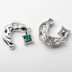 Detail of silver U-shape earring charms with green square crystal and honeycomb back