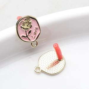 Detailansicht der rosa Emaille-Rosenohrringe mit Love-Schriftzug und Gold-Textur