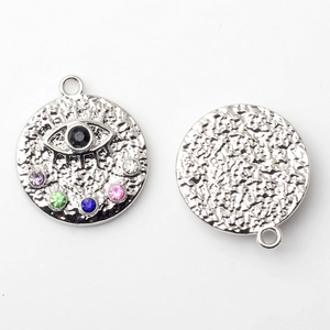 Detailed view of hammered texture and colorful evil eye pendant with crystal settings