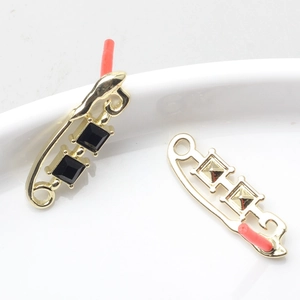 Dettaglio di ciondoli a graffetta dorati con cristalli neri per creazione gioielli
