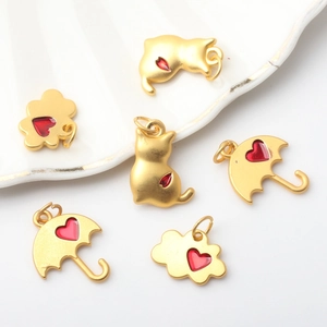 DIY jewelry charms set featuring gold cat, cloud, and umbrella with red heart drops